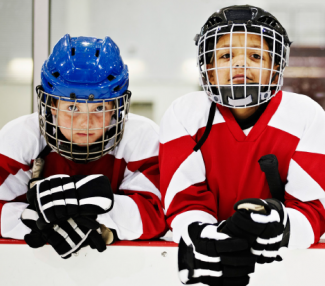 Two kids in hockey equipment